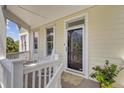 Inviting porch with rocking chairs, potted flowers, and view of the trees at 1647 Marsh Harbor Ln, Mount Pleasant, SC 29464