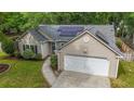 Aerial view of a single-Gathering home highlighting the solar panels, landscaping, and two-car garage at 1939 Oak Tree Ln, Mount Pleasant, SC 29464