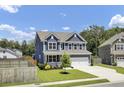 Charming two-story home features a manicured lawn, blue siding, and a two-car garage at 203 Plowden Mill Ct, Summerville, SC 29485