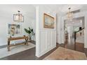 Elegant hallway showcasing dark wood floors, neutral walls, and a view into an office space with stylish decor at 2242 Dewees Creek Dr, Mount Pleasant, SC 29466