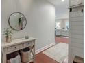 Inviting entryway with wood floors, a round mirror, console table, and view into the kitchen at 2244 Ashley Crossing Dr # 532, Charleston, SC 29414