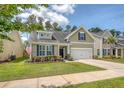 Well-kept home featuring a green lawn and symmetrical landscaping design at 227 Spectrum Rd, Summerville, SC 29486