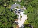 An aerial view of a home surrounded by trees shows its driveway, multiple stories, and charming design elements at 24 Beachwood West, Isle of Palms, SC 29451