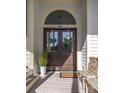 The house's double front doors are decorated with wreaths and a welcoming entry provides a seating area and potted plant at 24 Beachwood West, Isle of Palms, SC 29451