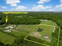 Aerial view of Angel Plantation estate featuring gated grounds, horse paddocks, and a private pond at 2470 Breakaway Trl, Johns Island, SC 29455