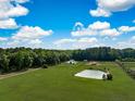 Expansive aerial view of a beautiful estate with a serene pond and lush green pastures at 2470 Breakaway Trl, Johns Island, SC 29455