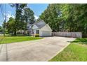 Spacious driveway leading to a well-maintained home with an attached garage and fenced backyard at 2916 Shadow Ln, North Charleston, SC 29406