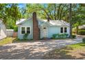 Cozy light blue home features a brick chimney, mature trees, and a metal roof at 309 Padgett Loop, Walterboro, SC 29488