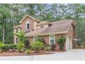 Side view of the home showing the brick exterior, attached garage, and surrounding greenery at 320 Compton Xing, Summerville, SC 29485