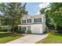 Daytime view of a charming two-story home featuring a cozy front porch, a garage, and landscaped yard at 334 Mossy Oak Way, Mount Pleasant, SC 29464