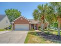 Charming brick home features a well-maintained lawn and a spacious two-car garage at 422 Cabrill Dr, Charleston, SC 29414
