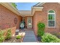 Charming entrance with a cozy chair, front yard flower beds, and brick facade at 422 Cabrill Dr, Charleston, SC 29414