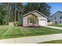 A well-maintained single-story home with a brick facade, an attached garage, and a lush green lawn at 510 Shady Maple St, Moncks Corner, SC 29461
