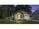 Single-story home at dusk with a brick facade, an attached garage, and a lawn at 510 Shady Maple St, Moncks Corner, SC 29461