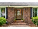 Close-up view of the brick front porch with decorative plants leading to the charming front door of the home at 614 Beauregard St, Charleston, SC 29412