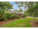 A well-maintained brick home with lush landscaping, mature trees, and a manicured lawn creates a welcoming curb appeal at 614 Beauregard St, Charleston, SC 29412
