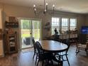 Cozy dining area featuring wood floors, a modern chandelier, and sliding glass doors to the outdoor patio at 677 Redbud Ln, Summerville, SC 29486