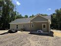 Back exterior featuring a covered porch and spacious lot, offering relaxing outdoor living and views of surrounding trees at 729 Burlington Rd, Walterboro, SC 29488