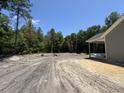Expansive lot with a covered porch and view of surrounding green trees, offering plenty of space and privacy at 729 Burlington Rd, Walterboro, SC 29488
