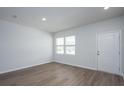 Bright, empty bedroom featuring light hardwood flooring, recessed lighting, and one window overlooking the yard at 737 Meadowbrook Ln, Summerville, SC 29486