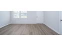 Unfurnished living room showcasing wood-look floors, white trim, and a door to the backyard at 737 Meadowbrook Ln, Summerville, SC 29486