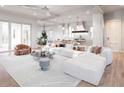 Bright and airy living room featuring a large sectional sofa, modern lighting, and hardwood floors at 814 Palm Blvd, Isle of Palms, SC 29451