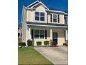 Inviting two-story home featuring black shutters, a covered porch, and manicured landscaping at 9088 Parlor Dr, Ladson, SC 29456