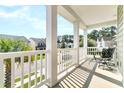 A cozy balcony with seating offers a pleasant view of the neighborhood street at 9829 English Elm St, Ladson, SC 29456