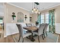 Stylish dining room with wainscoting, a rustic wood table, elegant chairs, and modern light fixture at 9829 English Elm St, Ladson, SC 29456