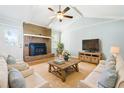 Comfortable living room features a brick fireplace, ceiling fan, and natural light for a cozy atmosphere at 101 Parkside Dr, Goose Creek, SC 29445