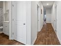 Hallway with wood floors, white doors, leading to a bathroom with a sink, toilet, and shower at 1014 Peridote Way, Ladson, SC 29456