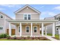 Charming two-story home featuring a welcoming front porch with stately white columns and a well-manicured lawn at 1017 Marsh Royal St, Summerville, SC 29485