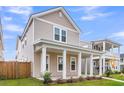 Charming two-story home featuring a welcoming front porch with stately white columns and a well-manicured lawn at 1017 Marsh Royal St, Summerville, SC 29485