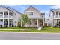 Charming two-story home featuring a welcoming front porch with stately white columns, lawn, and street view at 1017 Marsh Royal St, Summerville, SC 29485