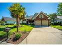 Inviting brick home with manicured lawn, palm trees, and wide driveway leading to a two-car garage at 105 Northpark Ave, Summerville, SC 29485