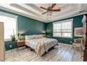 Comfortable main bedroom featuring white plank floors, a ceiling fan, and natural lighting at 106 Sago Palm Ct, Summerville, SC 29483