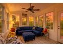 Cozy sunroom with a blue sectional couch, ceiling fan, and multiple windows offering natural light at 106 Sago Palm Ct, Summerville, SC 29483