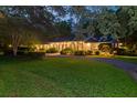 Inviting brick home illuminated at dusk, showcasing manicured landscaping and a charming, winding driveway at 108 E Walker Dr, Summerville, SC 29483