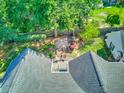 A view of the roof and backyard space, complete with a patio, garden area, and mature trees at 1111 Ole South Ct, Moncks Corner, SC 29461