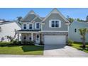 Charming two-story home boasts a mix of stone and siding, enhanced by a lush green lawn and twilight sky at 121 Cherry Grove, Summerville, SC 29483