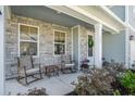 Inviting front porch featuring stone accents, rocking chairs, and a welcoming wreath on the door at 121 Cherry Grove, Summerville, SC 29483