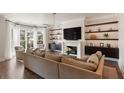 Elegant living room with hardwood floors, built-in shelving, a fireplace, and large windows with natural light at 122 Beaufain St # C, Charleston, SC 29401