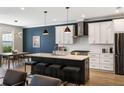 Open kitchen with a center island, counter seating, white cabinets, and stainless steel appliances at 1234 Captain Rivers Dr, Charleston, SC 29412
