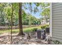 Idyllic backyard view showcasing a serene pond, lush greenery, and air conditioning units at 2317 Tall Sail Dr # 1005, Charleston, SC 29414