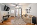 Cozy living room features hardwood floors, neutral decor, a ceiling fan, and large windows at 2515 Violet Ave, North Charleston, SC 29405