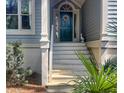 Close-up of a charming porch with a teal front door, decorative wreath, and traditional architectural details at 2655 Gnarled Pine, Seabrook Island, SC 29455