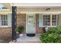 Inviting front porch featuring a light-blue door, brickwork, and decorative wrought-iron supports at 305 Forest Cir, Summerville, SC 29483