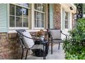 Relaxing porch with two chairs and a small table, showcasing the home's exterior at 305 Forest Cir, Summerville, SC 29483