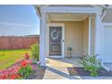 Inviting front porch with a decorated door, colorful flowers, and a manicured lawn at 307 Fox Gap Rd, Summerville, SC 29486