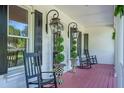 Close-up of front porch with black rocking chairs, decorative plants, and traditional lantern fixtures at 3130 Pignatelli Cres, Mount Pleasant, SC 29466